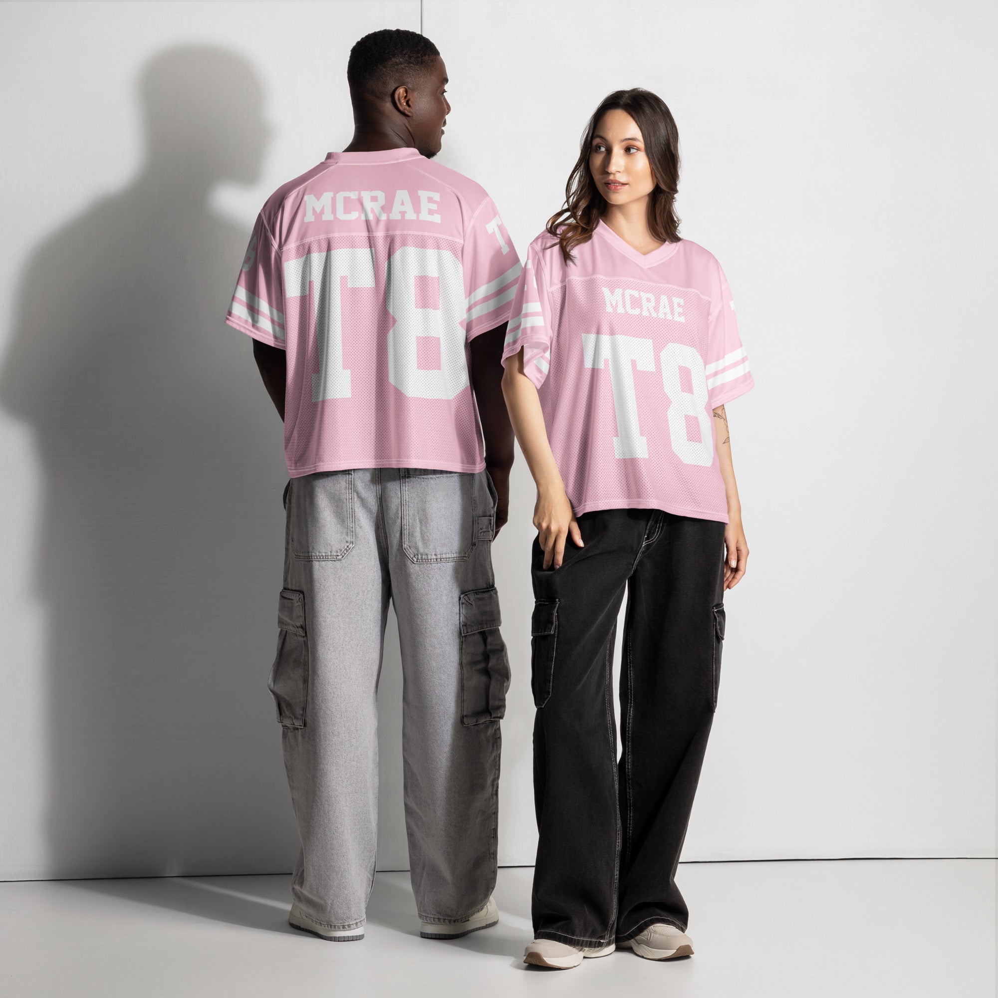 Two people wearing pink 'MCRAE ITB' t-shirts against a white background