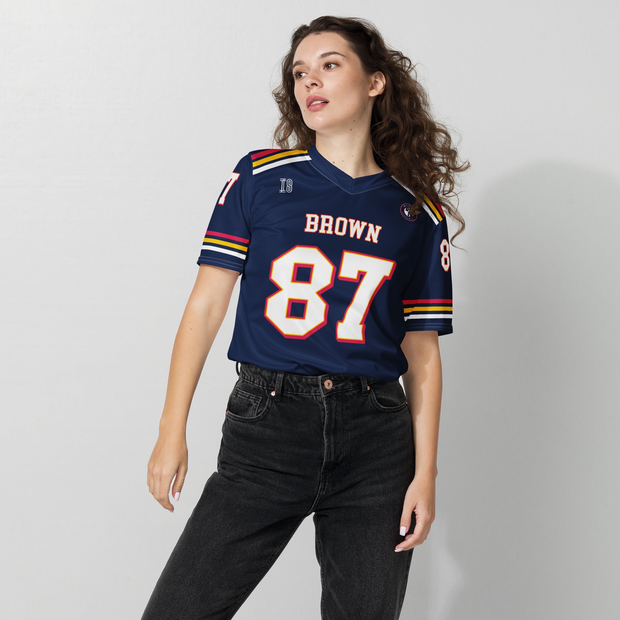 Woman wearing a blue sports jersey with the number 87 on a plain background
