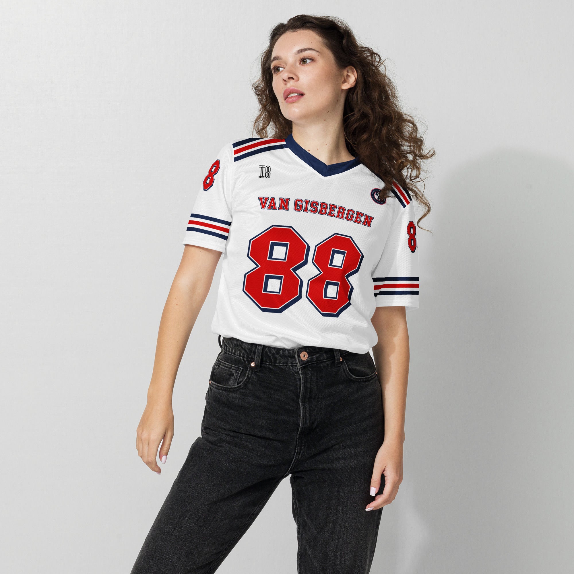 Woman wearing a white sports jersey with red and blue details on a plain background