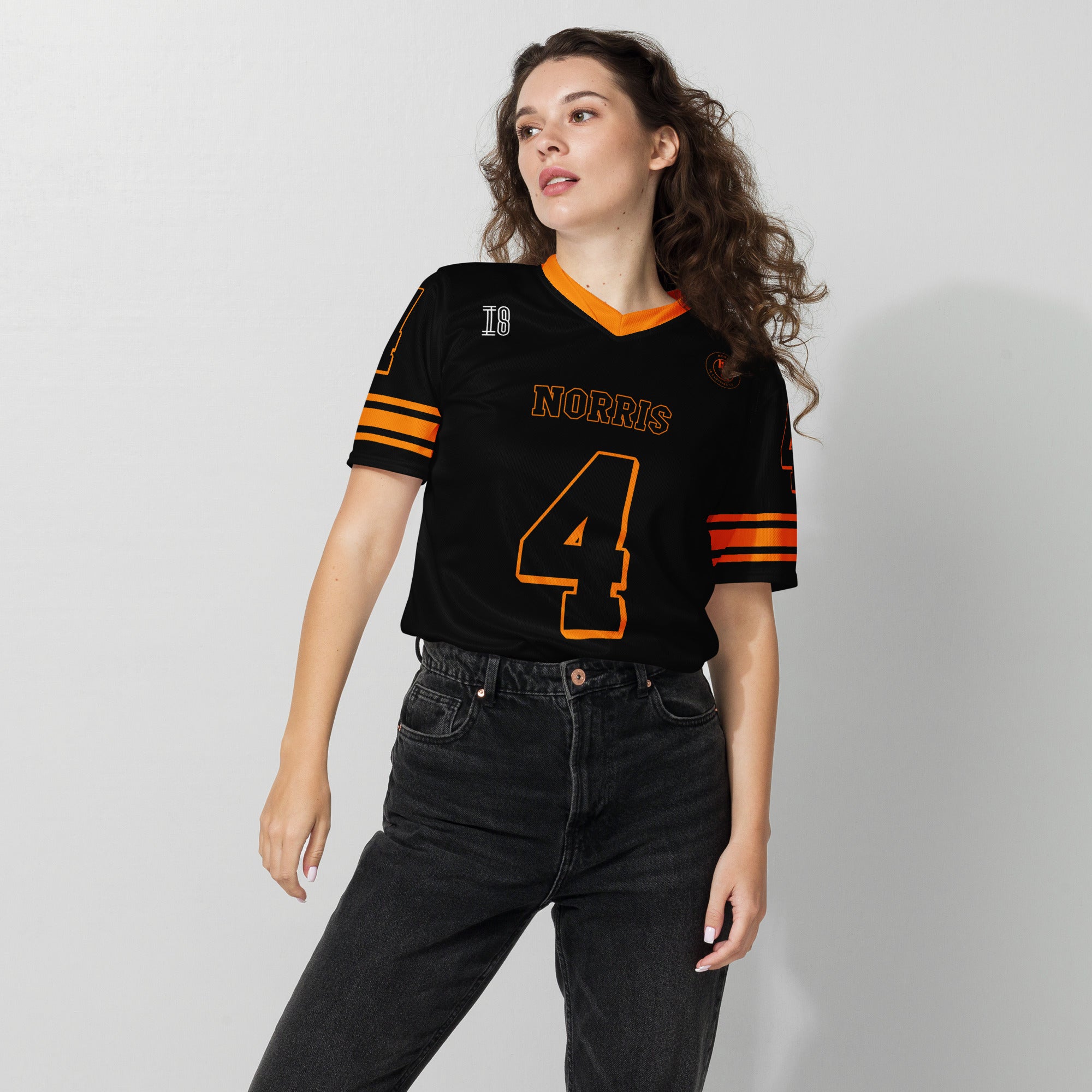 Person wearing a black sports jersey with orange accents and 'Norris 4' text on a plain background
