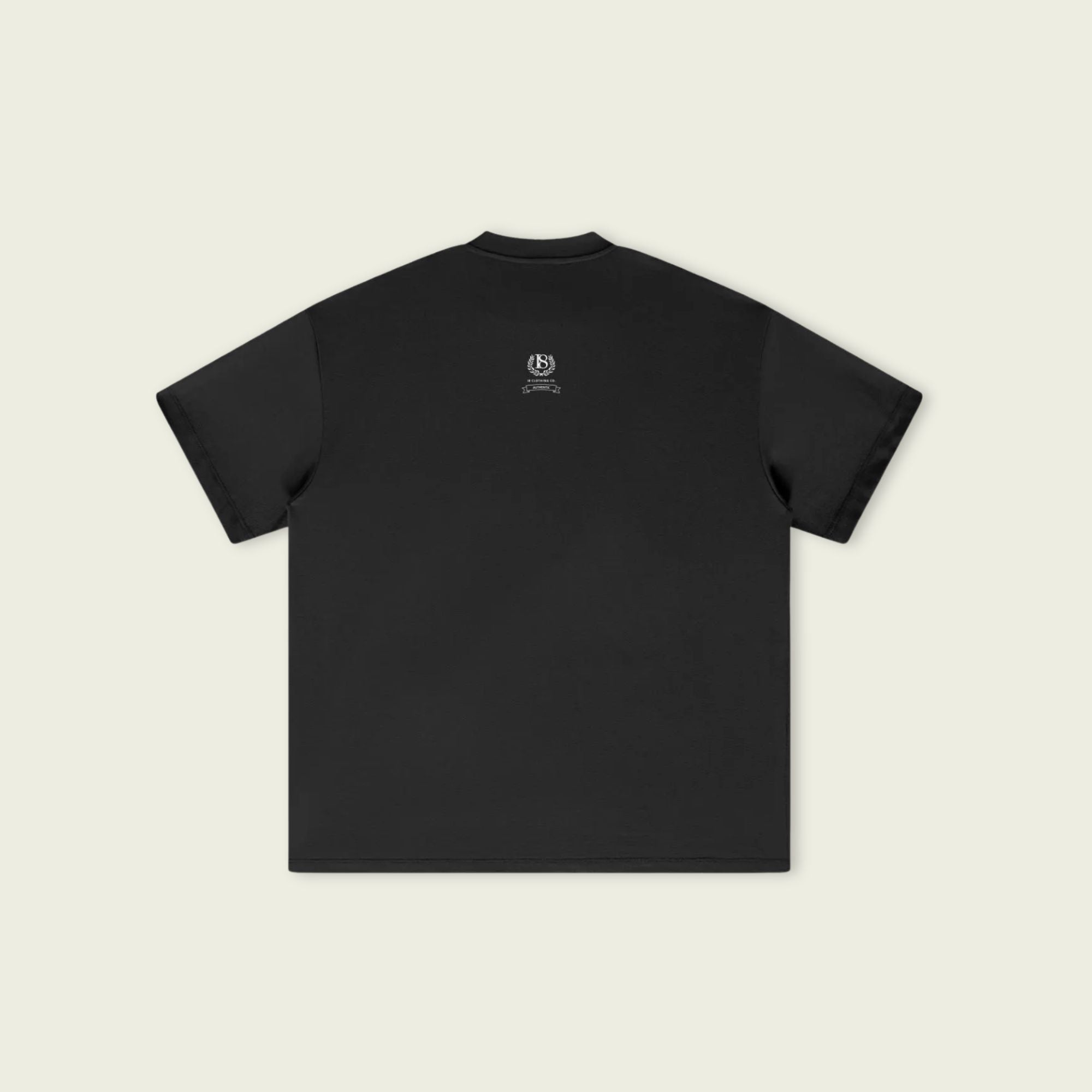 Black t-shirt with a small logo on the chest against a beige background
