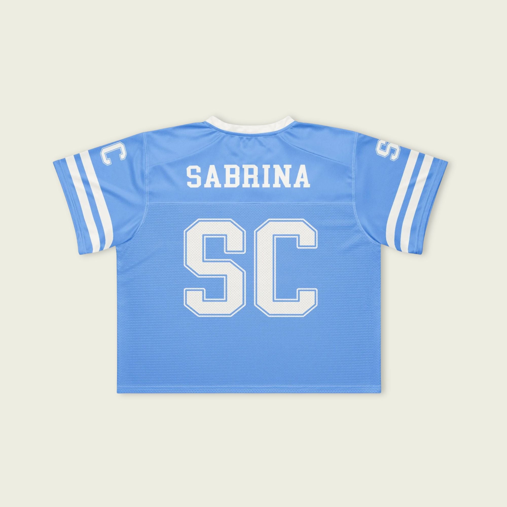 Light blue sports jersey with 'Sabrina' and 'SC' printed on the back against a beige background