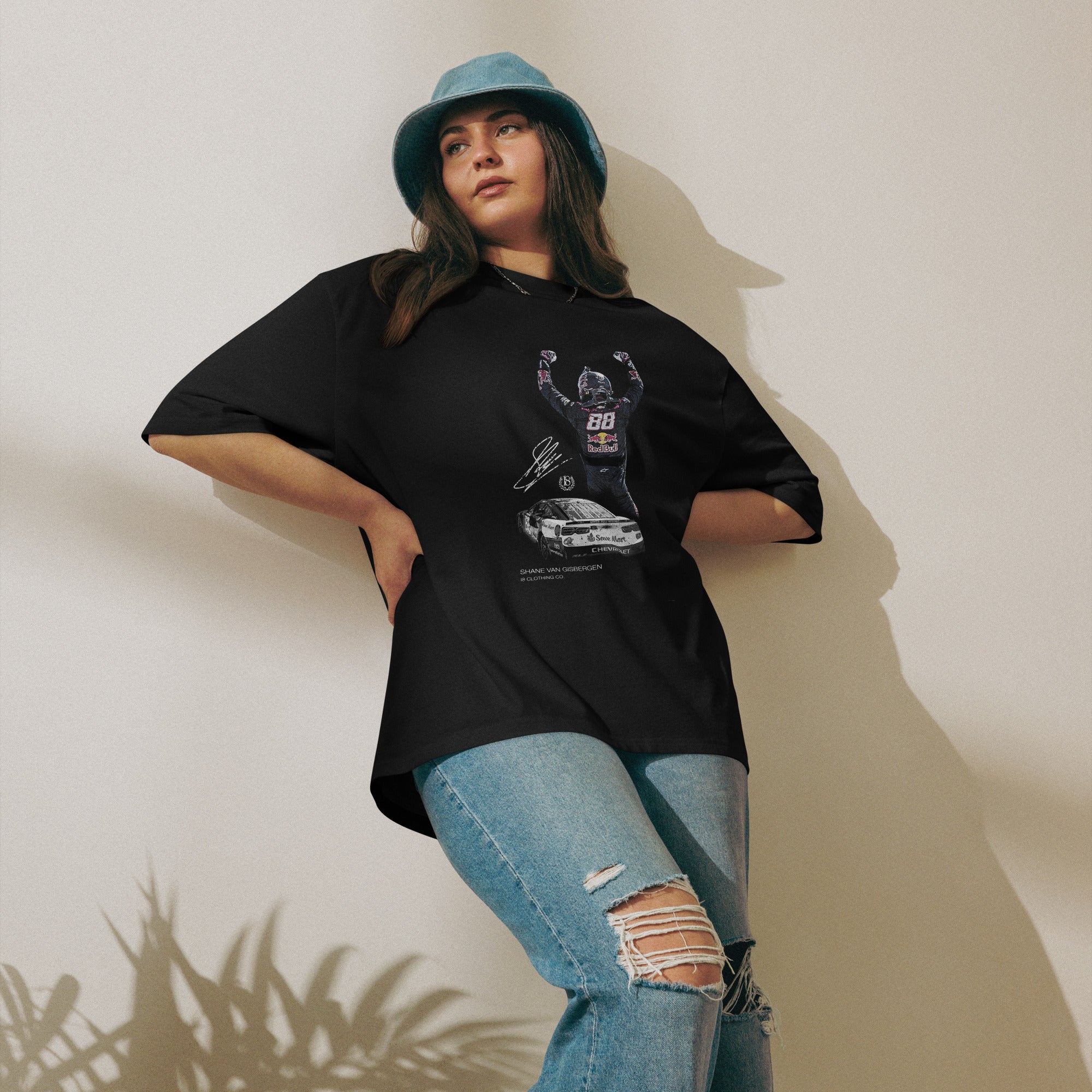 Person wearing a black t-shirt with graphic design and blue jeans against a plain background