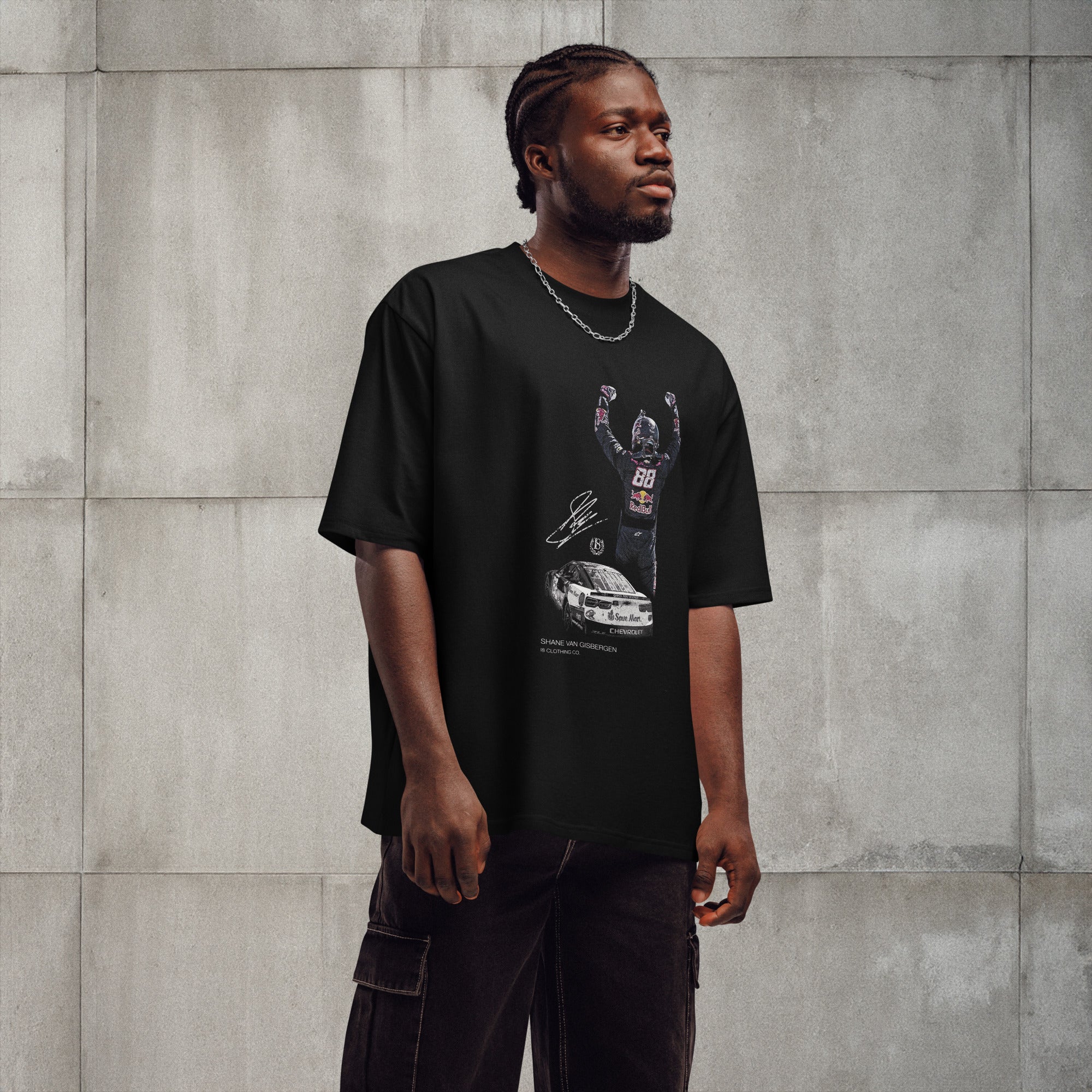 Man wearing a black t-shirt with graphic design against a gray concrete wall